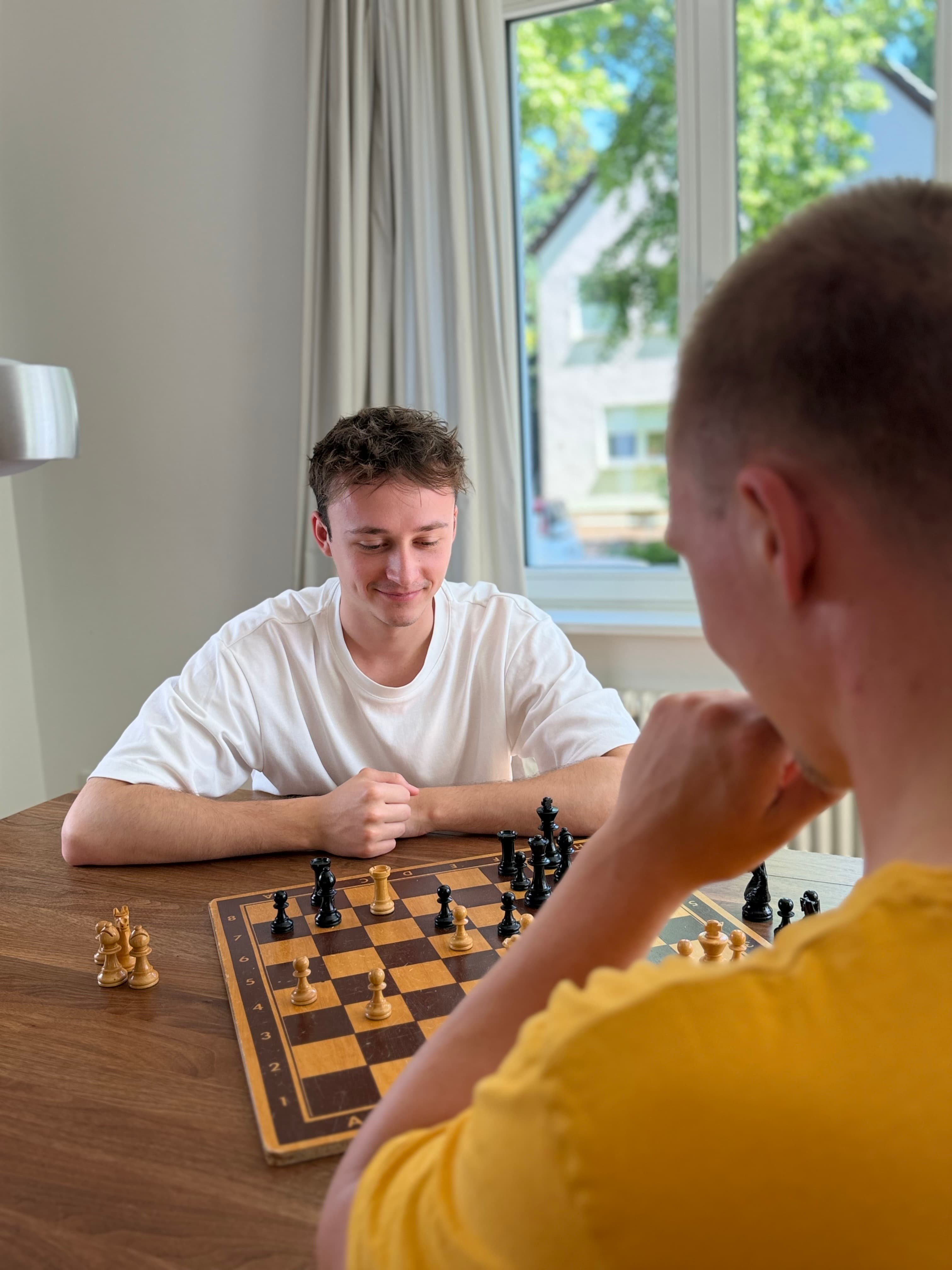 Zwei Menschen verschiedener Generationen spielen zusammen Schach.